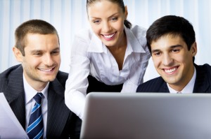 Three businesspeople working with laptop at office